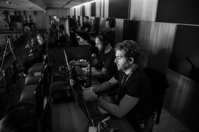 Equipe técnica operando som, luz e vídeos na régie